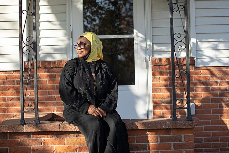 Woman sitting on front stoop of her home