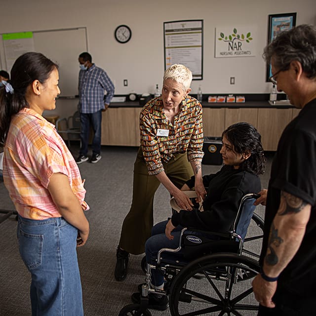 Nurse training class instructor showing students how to use a wheel chair properly