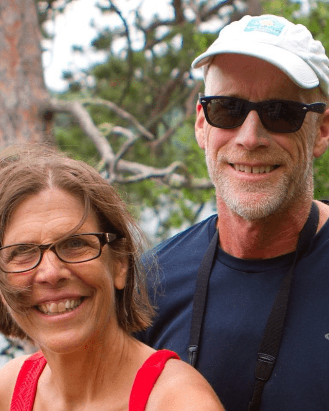 A husband and wife smile outside
