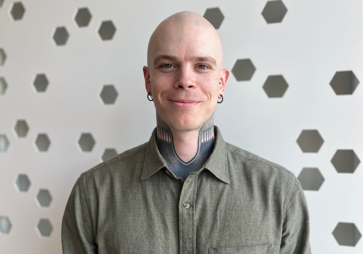 A bald white man with neck tattoos