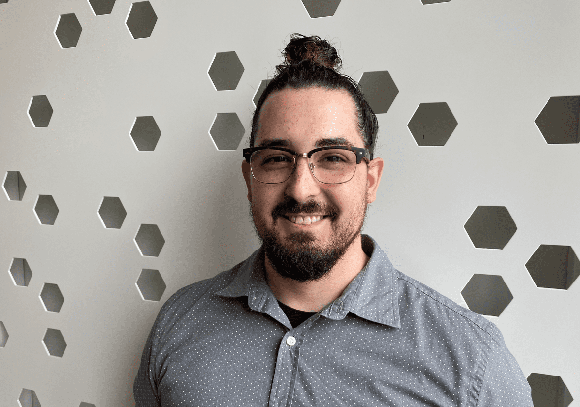 Man with gray, collared shirt and glasses